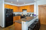 The fully equipped kitchen features a breakfast bar with barstool seating.